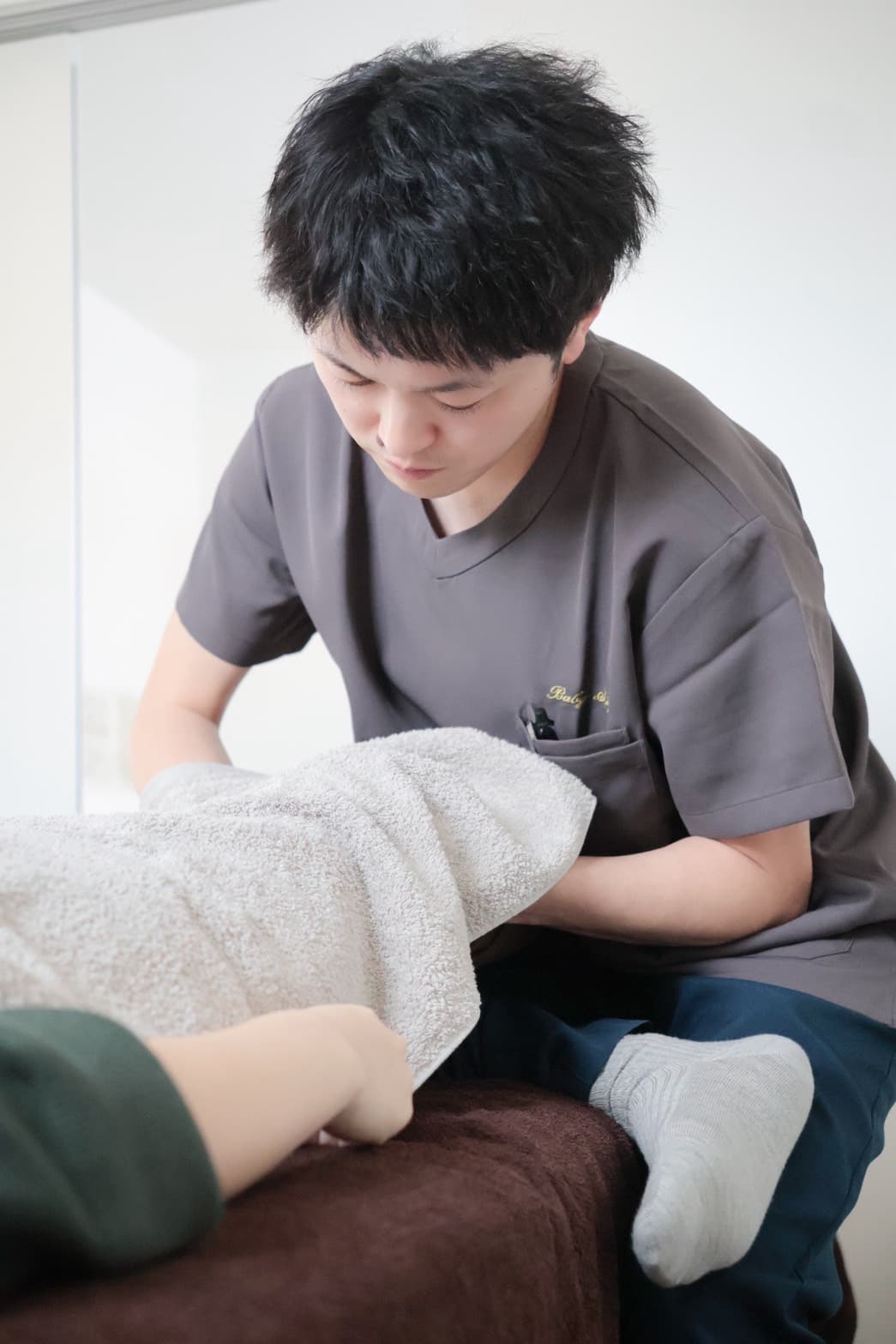 理学療法士による在宅での下肢の施術風景